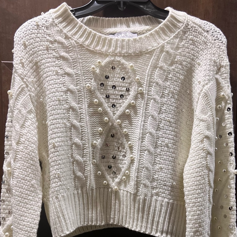 White bubble sleeve crop top sweater with pearl and sequin detailing.